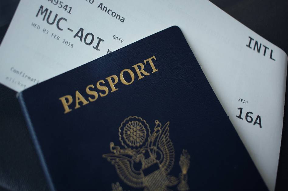 Woman reviewing travel insurance documents next to suitcase
